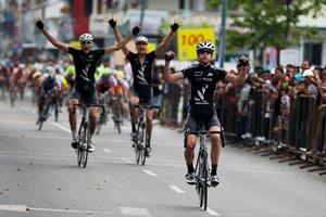 Michael Torckler crosses the line in first place during stage one of the Tour of Borneo, followed by Louis Crosby and Roman van Uden in 2nd and 3rd respectively